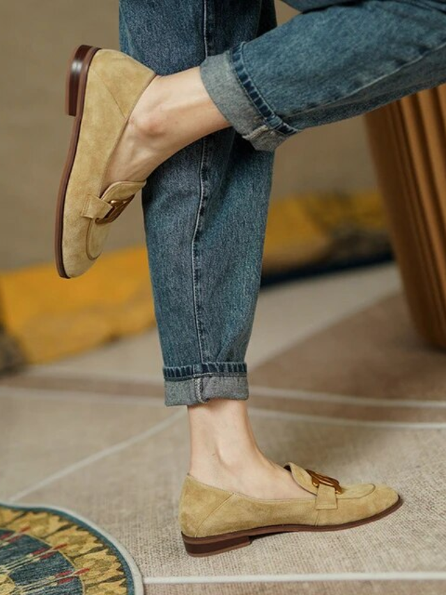  A woman in a chic outfit, sporting a pair of comfortable loafers.
