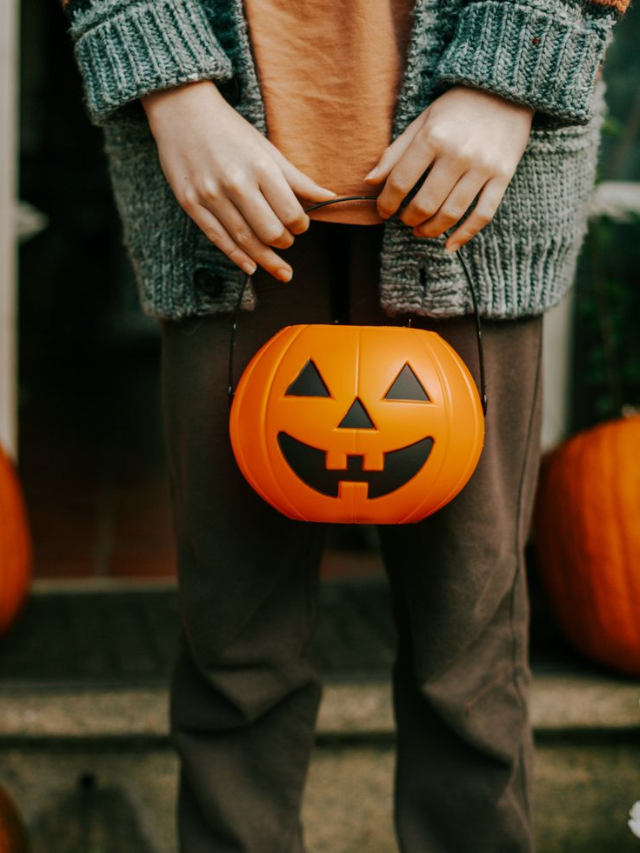 A group of costumed children holding trick-or-treat bags and smiling.
pen_spark
