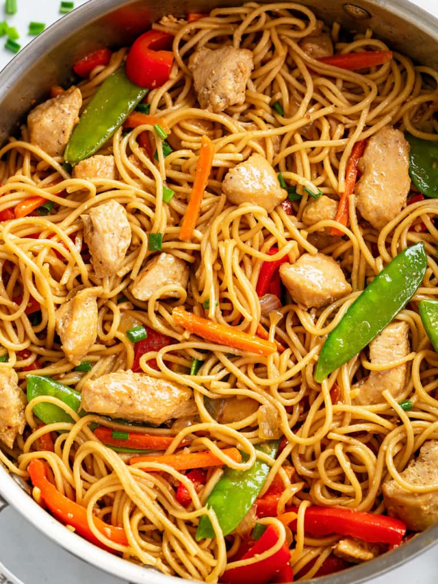 A close-up of a sizzling stir-fry with chicken, vegetables, and a flavorful sauce.
