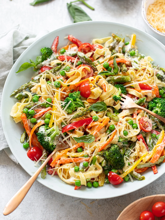  A steaming pot of creamy pasta with sausage and vegetables.
