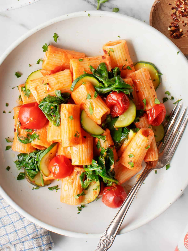 A steaming bowl of creamy tomato pasta with fresh basil.
