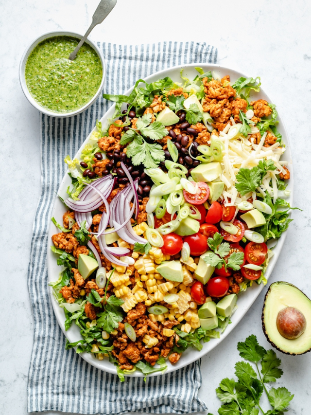 A hearty salad with grilled chicken, quinoa, avocado, and a vinaigrette dressing
