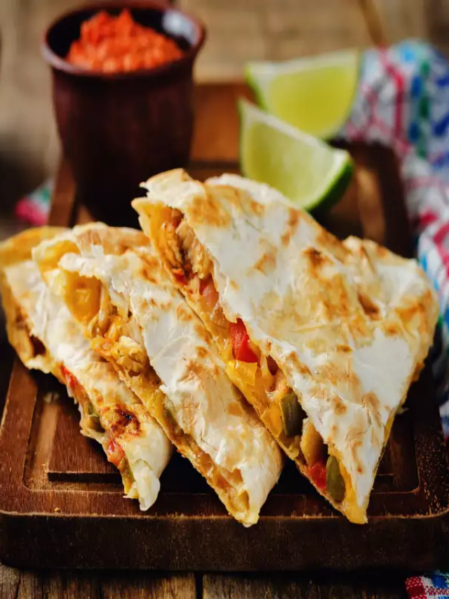  A golden brown quesadilla cut in half, revealing melted cheese and savory fillings.

