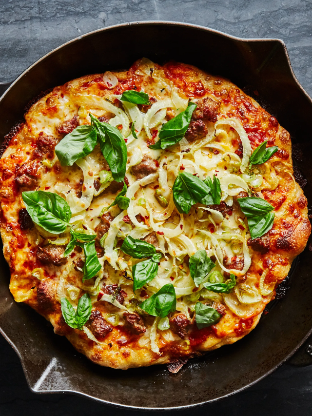 A cast iron skillet filled with browned merguez sausage, caramelized onions, and tender apple slices.
