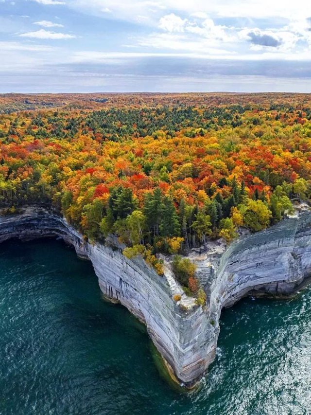 Hikers on a scenic trail in Pictured Rocks National Lakeshore, Michigan, surrounded by colorful sandstone cliffs.
