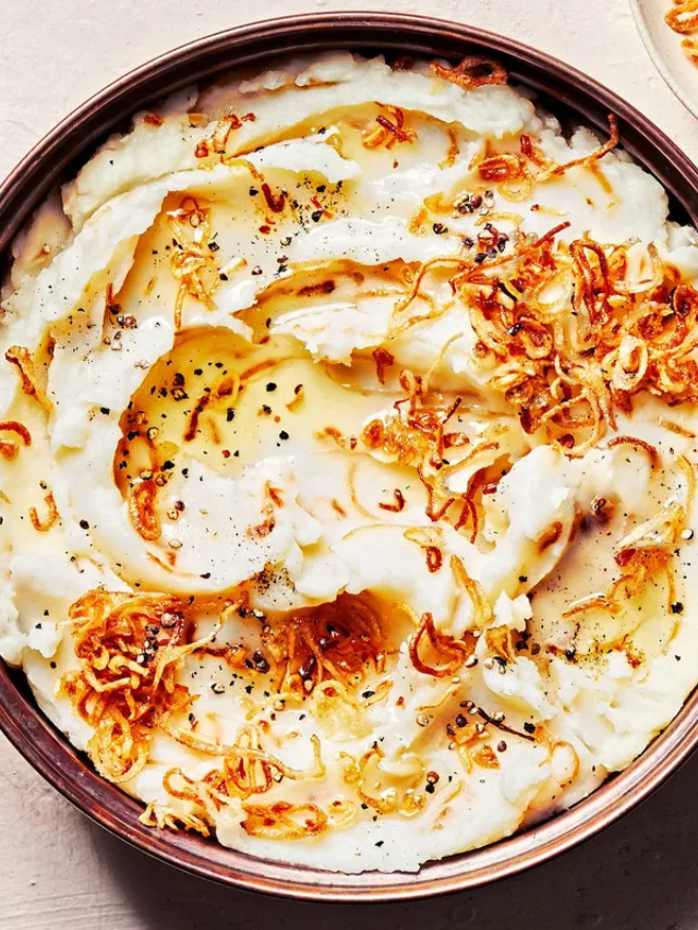  A plate with fluffy mashed potatoes and a dollop of butter.

