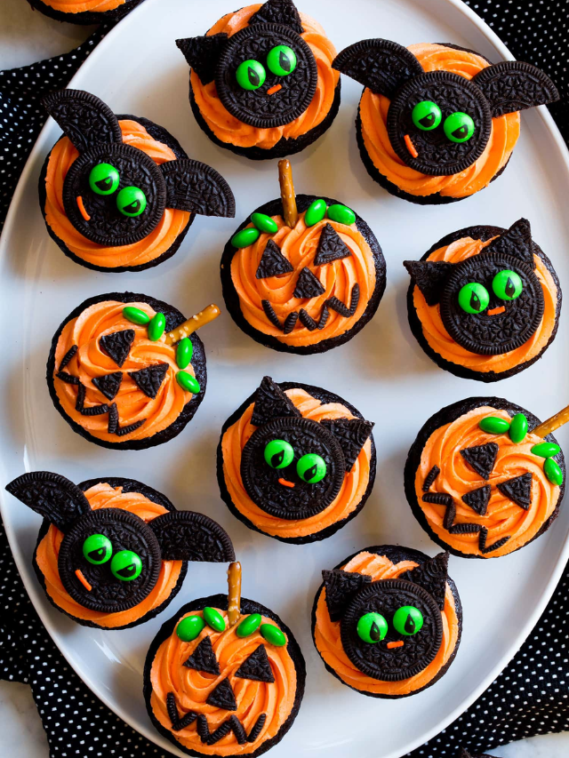A variety of Halloween-themed cookies and cupcakes decorated with ghosts, spiderwebs, and pumpkins.
