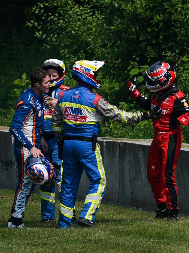 AMR Safety Team member talking to an IndyCar driver after a race.
