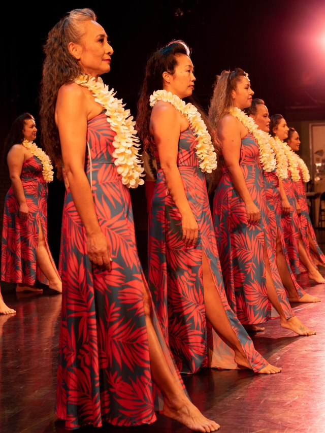 A group of friends laughing and having fun at a Polynesian dance class, learning the basic steps.
