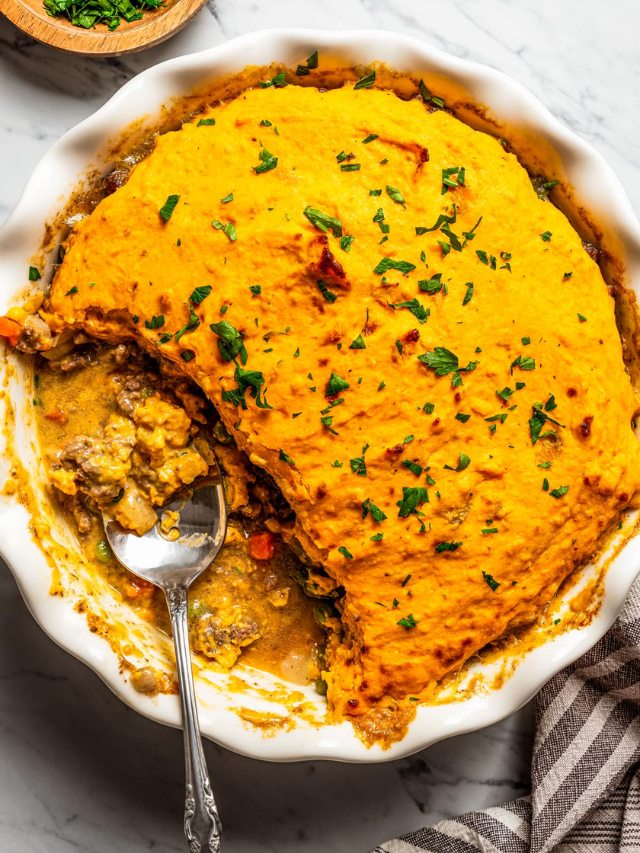 A shepherd's pie with a mashed potato topping being taken out of the oven.
