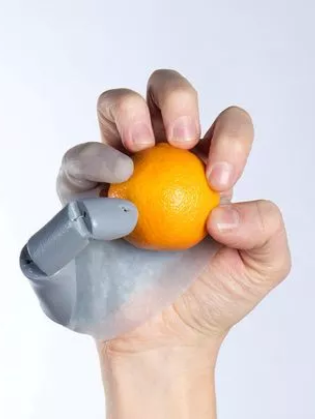 A person using the Third Thumb and their hand to manipulate an object.
