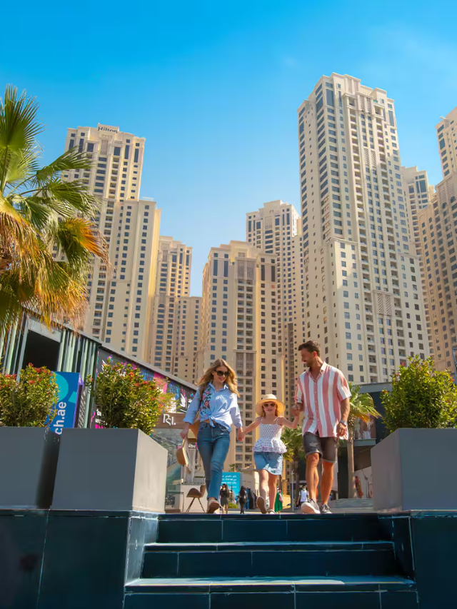 A photo of a lively outdoor shopping district with people browsing stores and enjoying the sunshine.
