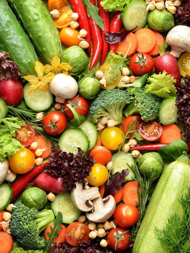 A person smiling and holding a plate of healthy food.
