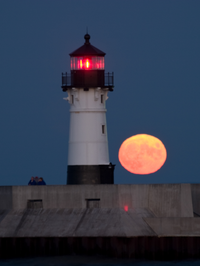 A montage of various Michigan attractions - a lighthouse, a bustling city skyline, a farmer's market, and a family enjoying a campfire.
