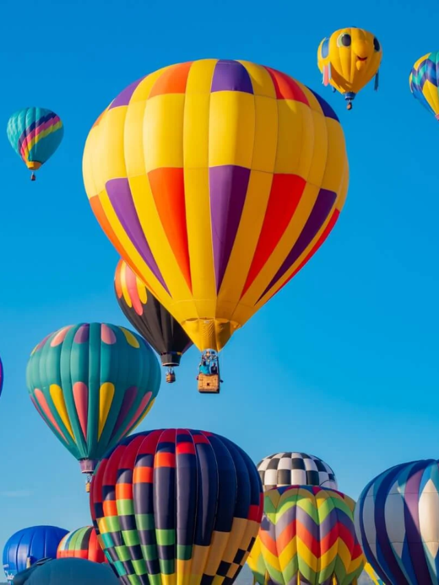 A photo of a hot air balloon floating over the Tempe skyline at sunset.
