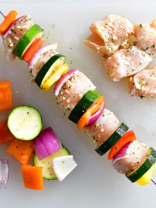 Colorful veggie and chicken kabobs on a grill
