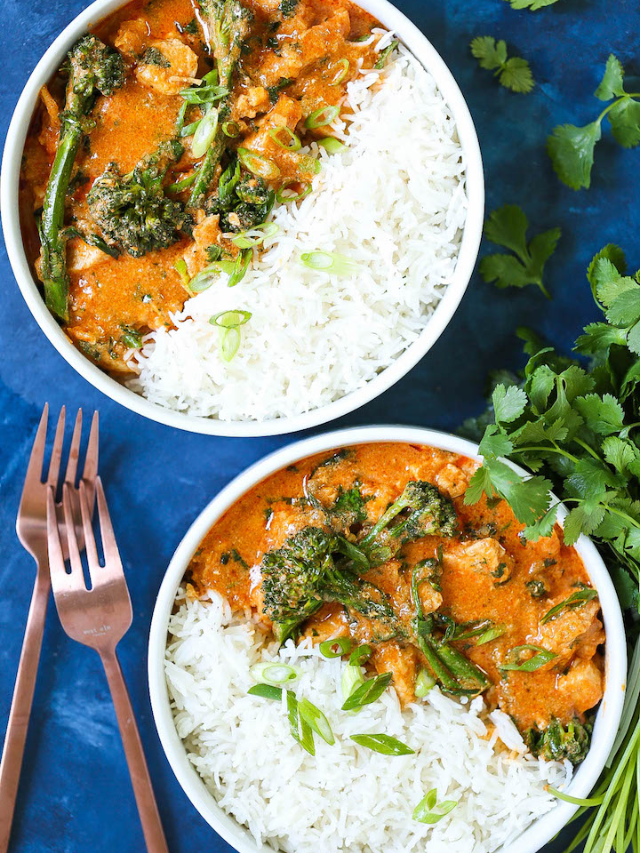 A close-up of a colorful Thai curry bowl with rice.
