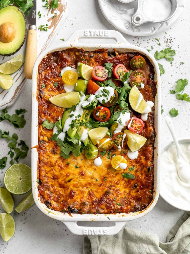 A photo of an enchilada casserole topped with green onions and olives.
