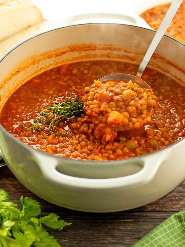 A steaming bowl of lentil soup with crusty bread on the side.
