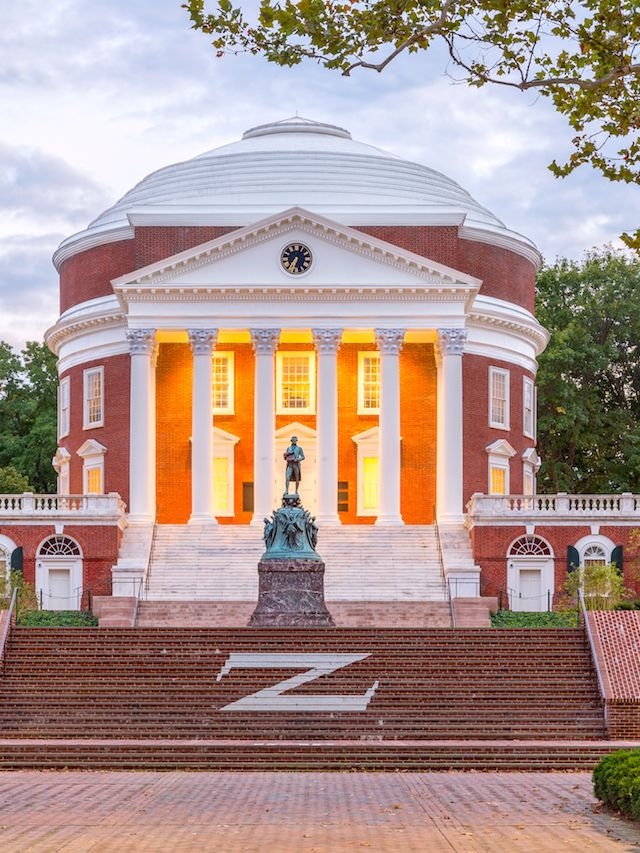 Tranquil scene of the University of Kentucky campus with red brick buildings and lush green lawns.

