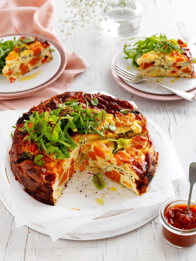  A close-up of a colorful and cheesy frittata with vegetables.
