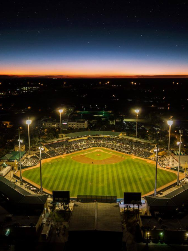 A panoramic view of a spring training baseball game at a Tempe stadium with fans cheering in the stands.
