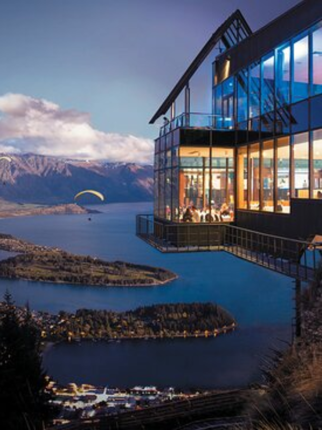 Family enjoying a delicious meal at a restaurant with a stunning lakefront view.
