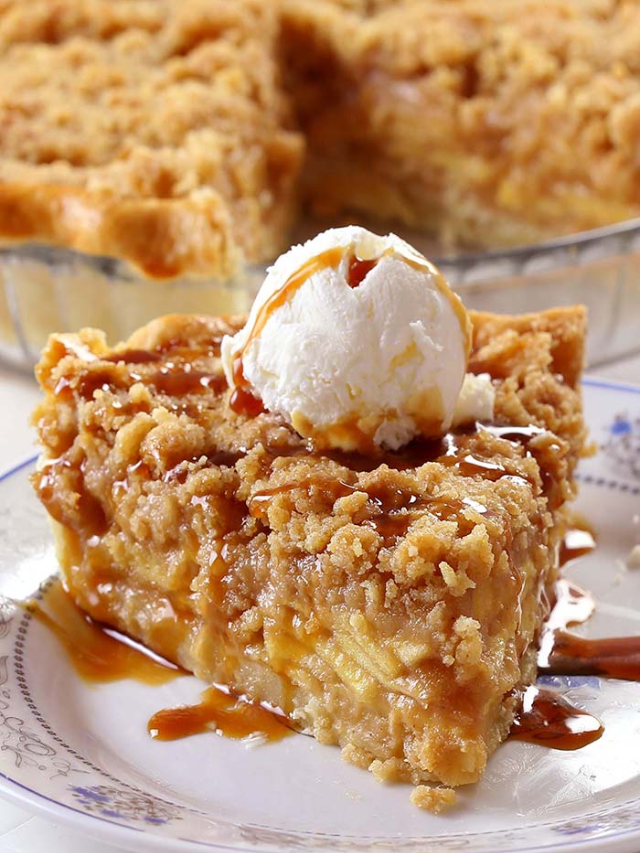 A crock pot filled with a bubbling apple crisp with a golden brown oat topping.
