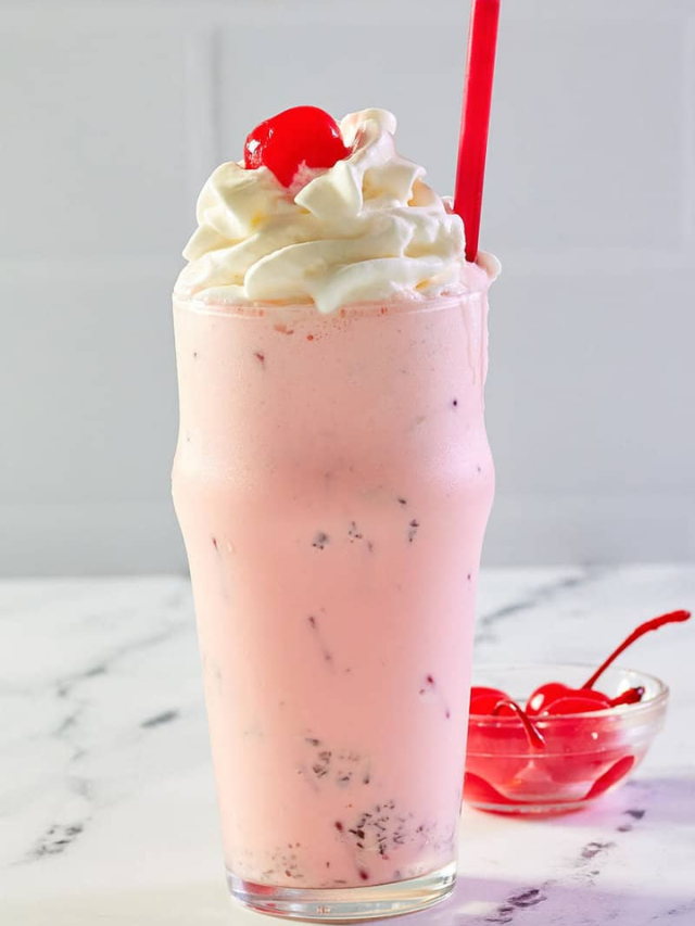 The shake is topped with whipped cream, vanilla wafer cookie crumbles, and a cherry.
